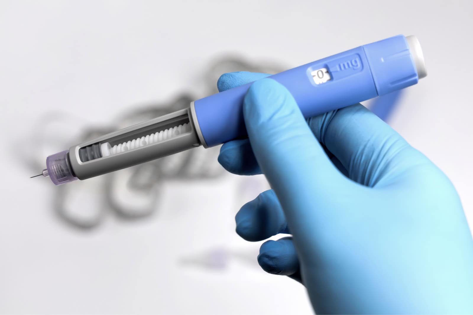 A close-up of a gloved hand holding a Semaglutide injection pen, highlighting the device used for administering this effective weight-loss medication.